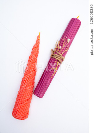 DIY wax candle making process. Woman making decorative wax candle and decorates with dried flowers, close-up of hands 126008386