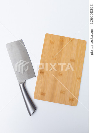 Top view of wooden cutting board, wooden spoons, knife and napkin on the white marble table.Empty space 126008398