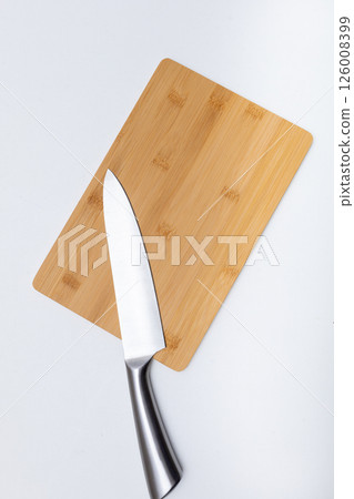 Topview of wooden chopping board and chef knife on the white table. Free space 126008399