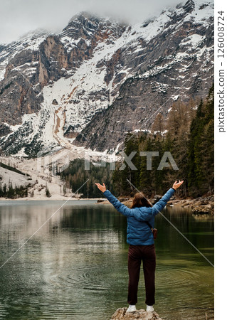 Mountain lake Braies in Italy. Girl in front of the lake looks at the beautiful landscape 126008724
