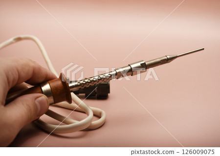 An old soldering iron with a silver tip. 126009075
