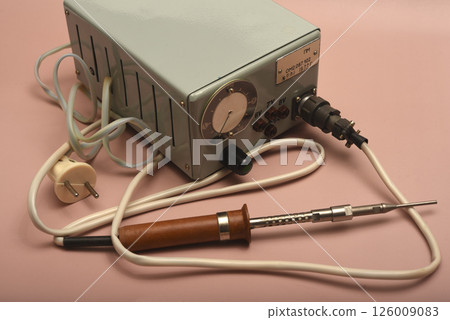 Retro soldering station. An old soldering iron with a silver tip. 126009083