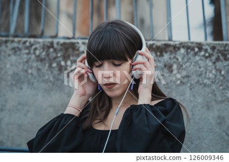 Woman Sitting In The City Bench Outdoor And Relaxing With Music Sound 126009346