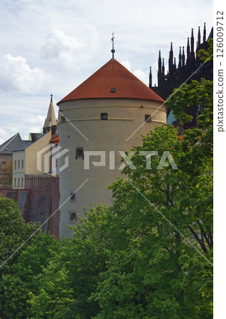Historic Tower With Red Tiled Roof Amid Lush Greenery 126009712
