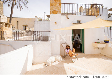 Mediterranean rooftop escape with dog and book 126010042