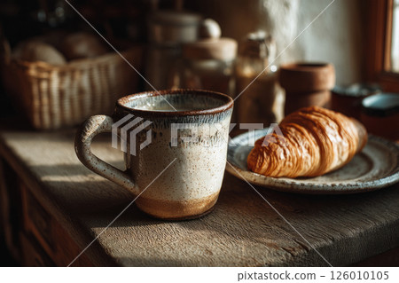 Rustic breakfast with ceramic mug and croissant in cozy kitchen 126010105