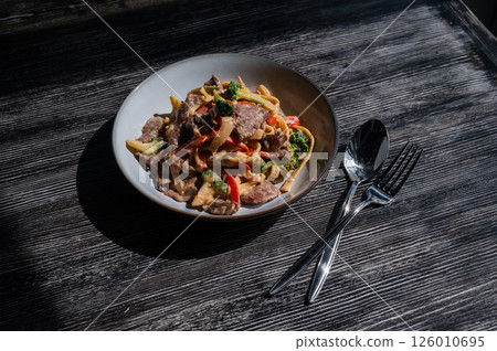 Pasta with beef, mushrooms and vegetables.  126010695