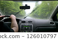 Driving in heavy rain. Interior view from the driver's seat. Wet windshield, blurred road and trees. Focus on the journey. Travel, transportation concept. 126010797
