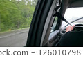 Driving in the rain. Interior view from the passenger seat. Wet window, blurred scenery. Focus on safety belt. Travel, transportation concept. 126010798