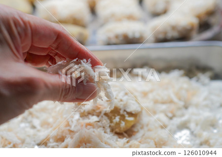A woman's hands making homemade croquettes using raw breadcrumbs A woman's hands making homemade croquettes using raw breadcrumbs 126010944