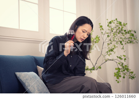 一名 40 多歲的女性白天在家喝酒 一名 40 多歲的女性白天在家喝酒 126011660
