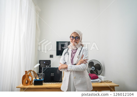 A confident female doctor stands proudly in a bright and welcoming clinic setting 126012104