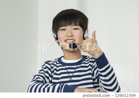A fourth grade boy wearing a headset 126012304