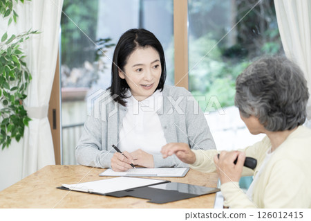Care manager/care manager conducting a home visit 126012415