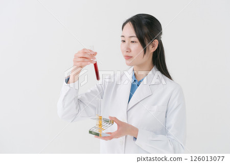一件白色服裝的一名婦女與試管 一件白色服裝的一名婦女與試管 126013077