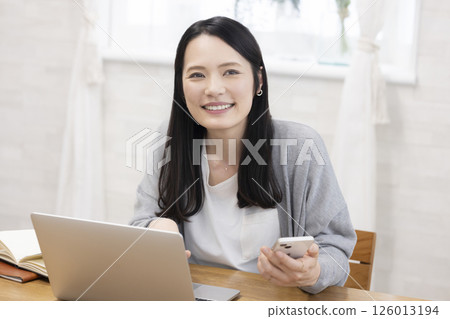 一位美麗的中年婦女面對電腦 一位美麗的中年婦女面對電腦 126013194