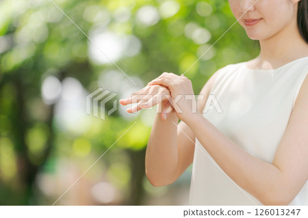 Woman applying cream on arm Woman applying cream on arm 126013247
