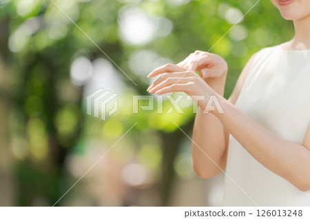 Woman applying cream on arm 126013248