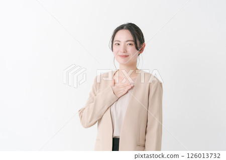A woman in her twenties in a suit with her hand on her chest 126013732