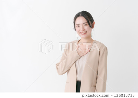 A woman in her twenties in a suit with her hand on her chest A woman in her twenties in a suit with her hand on her chest 126013733