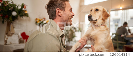 Close up portrait of cute dog and happy man, guy hugging his pet, spending time in animal-friendly cafe, waiting for an order Close up portrait of cute dog and happy man, guy hugging his pet, spending time in animal-friendly cafe, waiting for an order 126014514