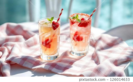 Two refreshing spring cocktails with lemon slices and ice on a table, perfect for a sunny day 126014633