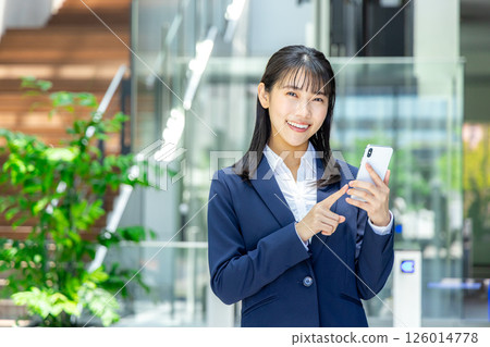 Business woman operating a smartphone Business woman operating a smartphone 126014778