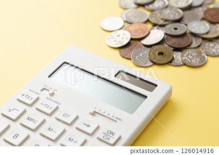 Coins and calculator on a yellow background 126014916