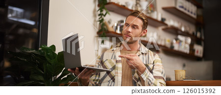 You got a point. Portrait of serious man agree with colleague, pointing finger at laptop screen, connects to video chat, has conversation with someone You got a point. Portrait of serious man agree with colleague, pointing finger at laptop screen, connects to video chat, has conversation with someone 126015392