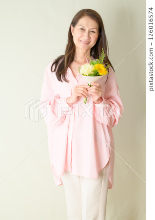 Senior woman holding flowers 126016574