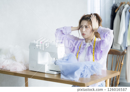 Young woman sewing with a sewing machine Young woman sewing with a sewing machine 126016587