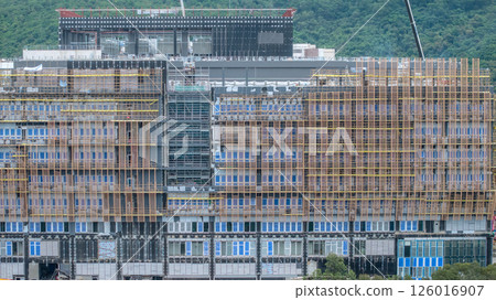 MAY 10 2025 Large Building Under Construction with Scaffolding and Mountain 126016907