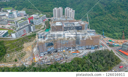 MAY 10 2025 View of a Large Urban Construction Site Amid Surrounding Greenery 126016911