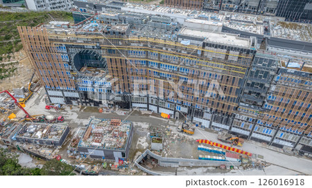 MAY 10 2025 View of a Large Urban Construction Site Amid Surrounding Greenery 126016918