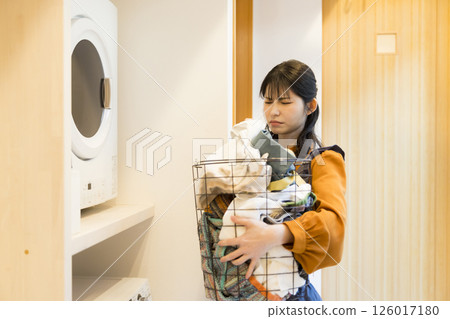 A woman taking laundry out of a drum washing machine 126017180