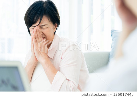 A middle-aged couple is shocked when looking at a computer in the living room 126017443