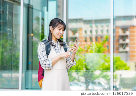 A young college student woman with a smartphone 126017589