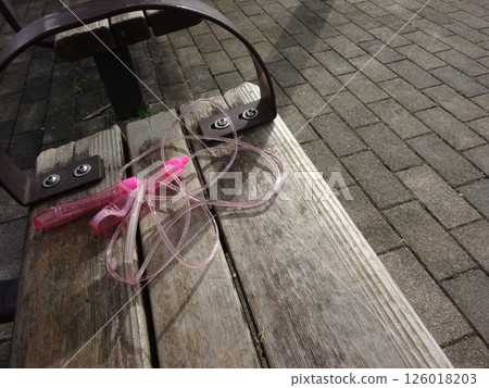 Skipping rope forgotten on a park bench Skipping rope forgotten on a park bench 126018203