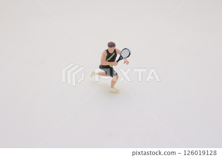Miniature Tennis Player in Action Preparing for a Serve on White Background Miniature Tennis Player in Action Preparing for a Serve on White Background 126019128