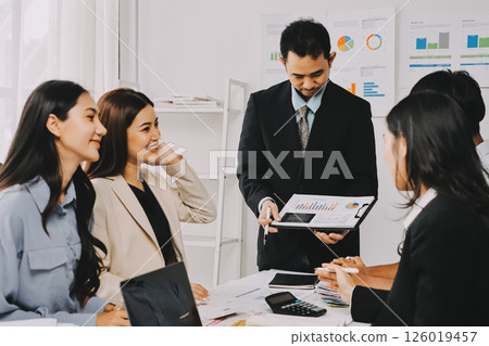 Team of financial advisory services. Asian advisor showing plan of investment to clients in the consultancy office. 126019457
