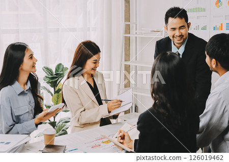 Team of financial advisory services. Asian advisor showing plan of investment to clients in the consultancy office. 126019462