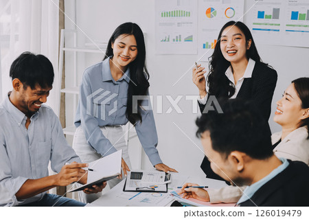 Team of financial advisory services. Asian advisor showing plan of investment to clients in the consultancy office. 126019479