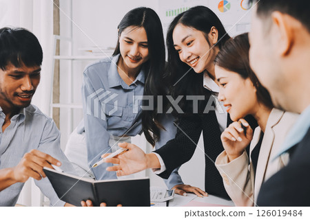 Team of financial advisory services. Asian advisor showing plan of investment to clients in the consultancy office. 126019484