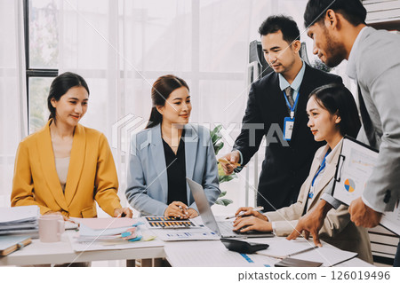 Team of financial advisory services. Asian advisor showing plan of investment to clients in the consultancy office. 126019496