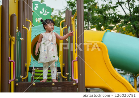 happy toddler girl playing at a outdoor playground in park 126020781