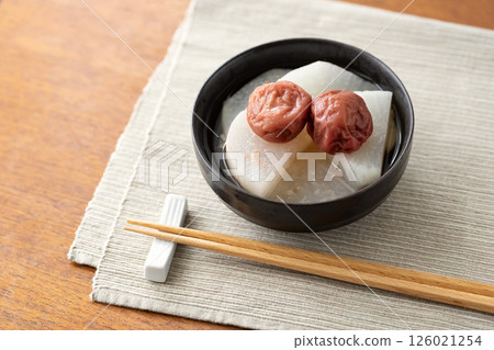 盛在黑色碗中的梅花、筷子和餐墊 盛在黑色碗中的梅花、筷子和餐墊 126021254