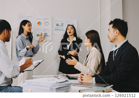 Team of financial advisory services. Asian advisor showing plan of investment to clients in the consultancy office. 126021512