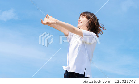 Summer blue sky and a smiling woman stretching 126021748