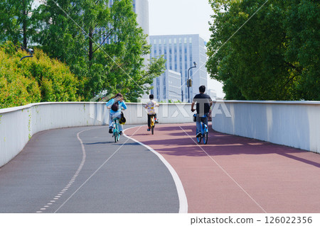 城市绿道上骑行的一家三口背影 城市绿道上骑行的一家三口背影 126022356