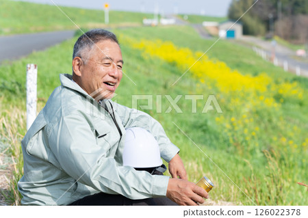 A senior supervisor taking a break with a can of coffee in hand 126022378